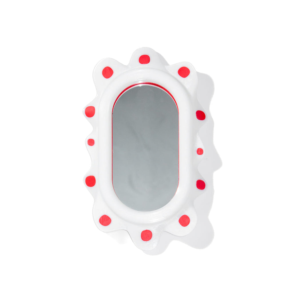 A decorative mirror inspired by sea slugs with red polka dots on a white background