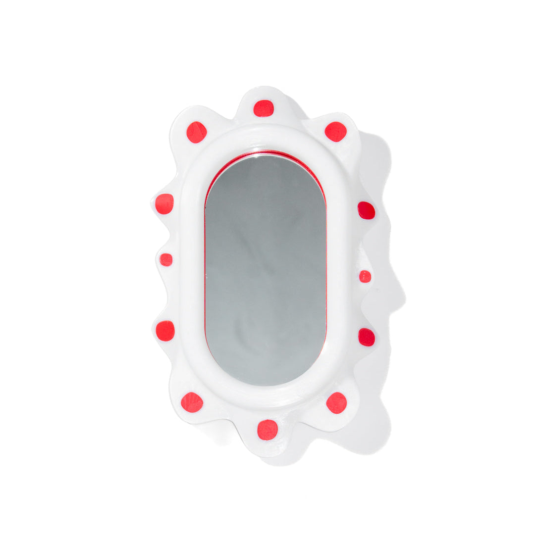 A decorative mirror inspired by sea slugs with red polka dots on a white background