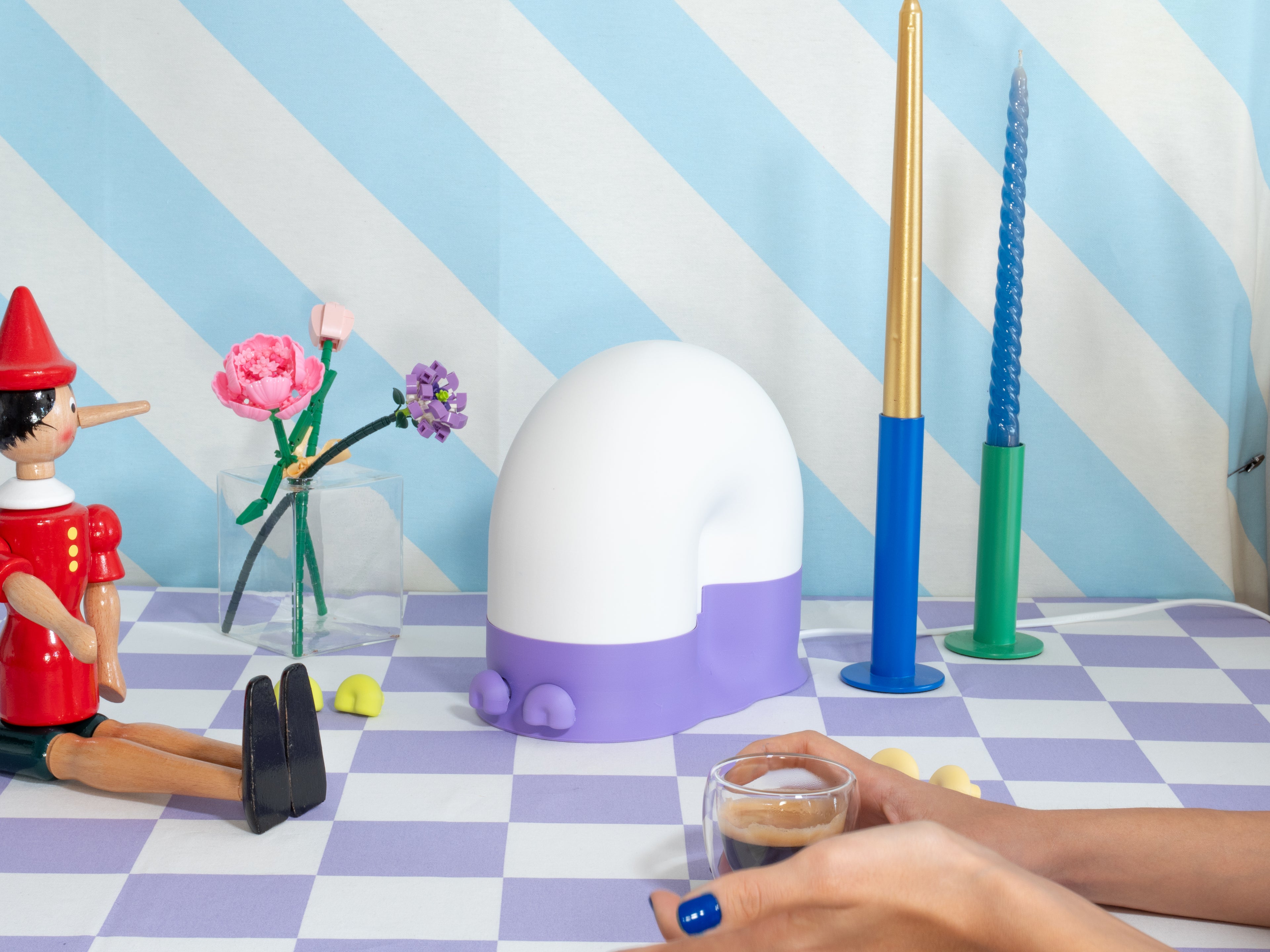Colorful decoration with a checkered floor, striped walls, and various objects including a snail lamp and a small table.