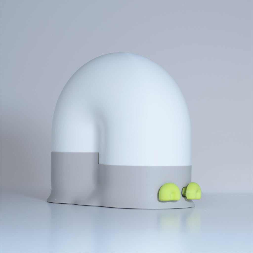 White snail-shaped lamp with a gray base and green eyes on a light gray background
