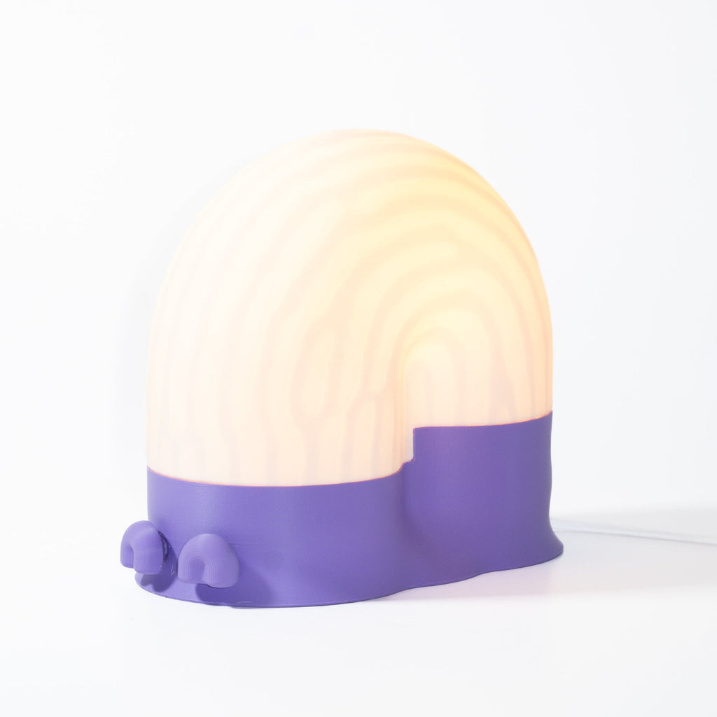 Round lamp with purple base and beige top on a white background