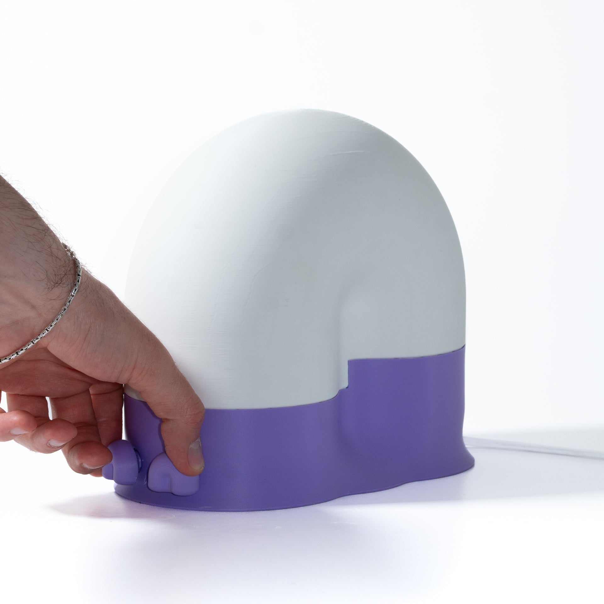 White and purple device held by a hand on a white background
